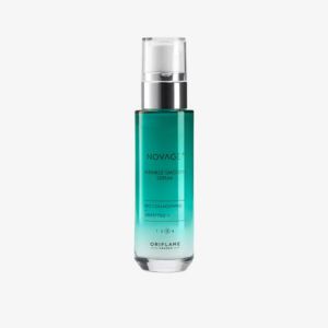 Novage+ anti-ageing facial serum in a sleek turquoise-green glass bottle with a silver pump dispenser and transparent cap, isolated on a light gray background.
